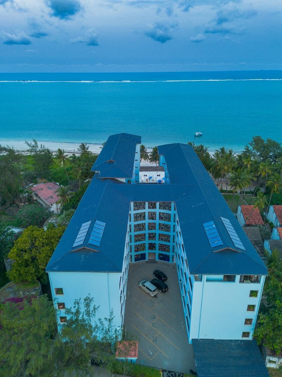 Aerial view of a beach resort with a blue Muwi ACT roof